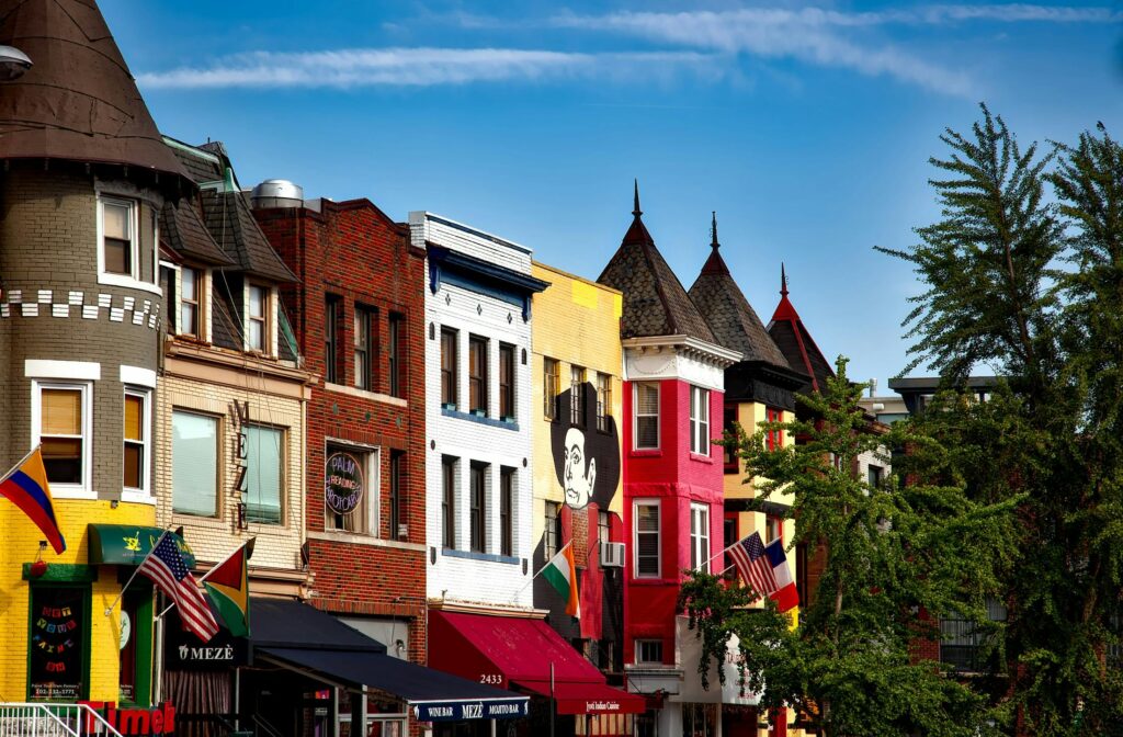 Vibrant row of buildings with murals and flags in Adams Morgan, Washington DC.